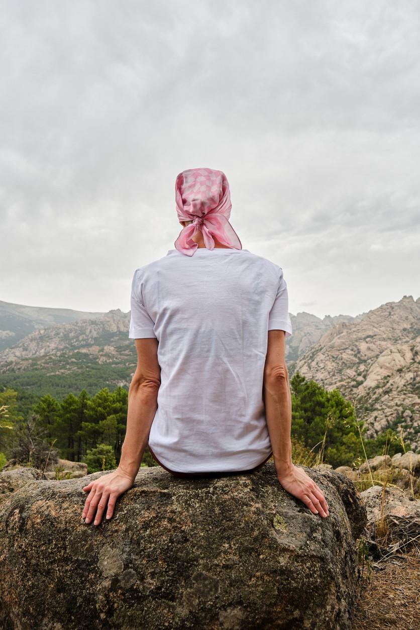 Woman with cancer on rock