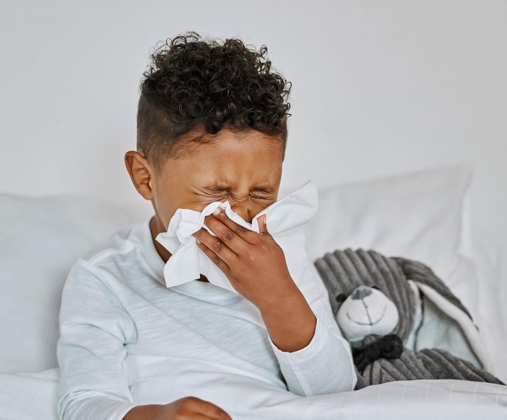 Young boy blowing nose