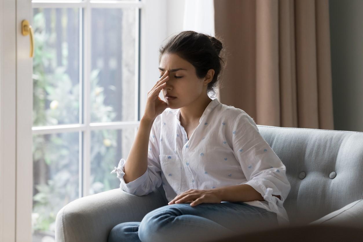 Young woman on couch with headache