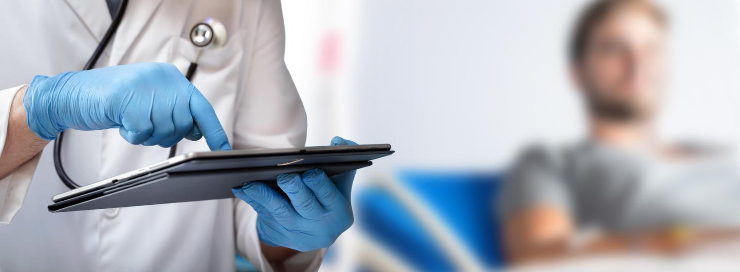 Man in hospital and doctor looking at tablet