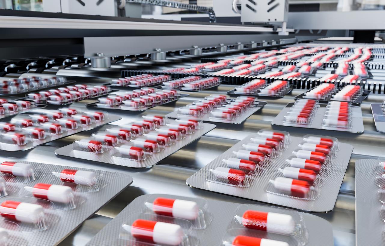 Red and white capsules in blister packs on production line