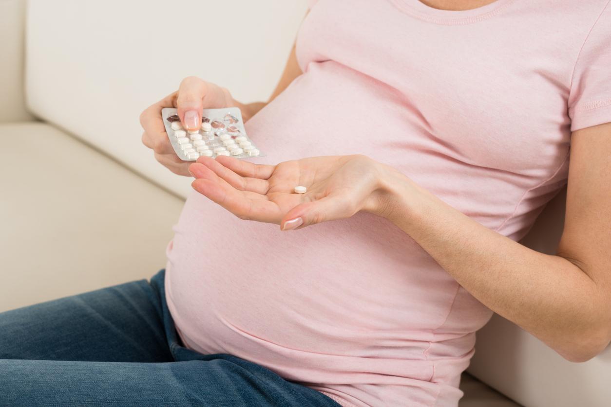 Pregnant woman holding pills