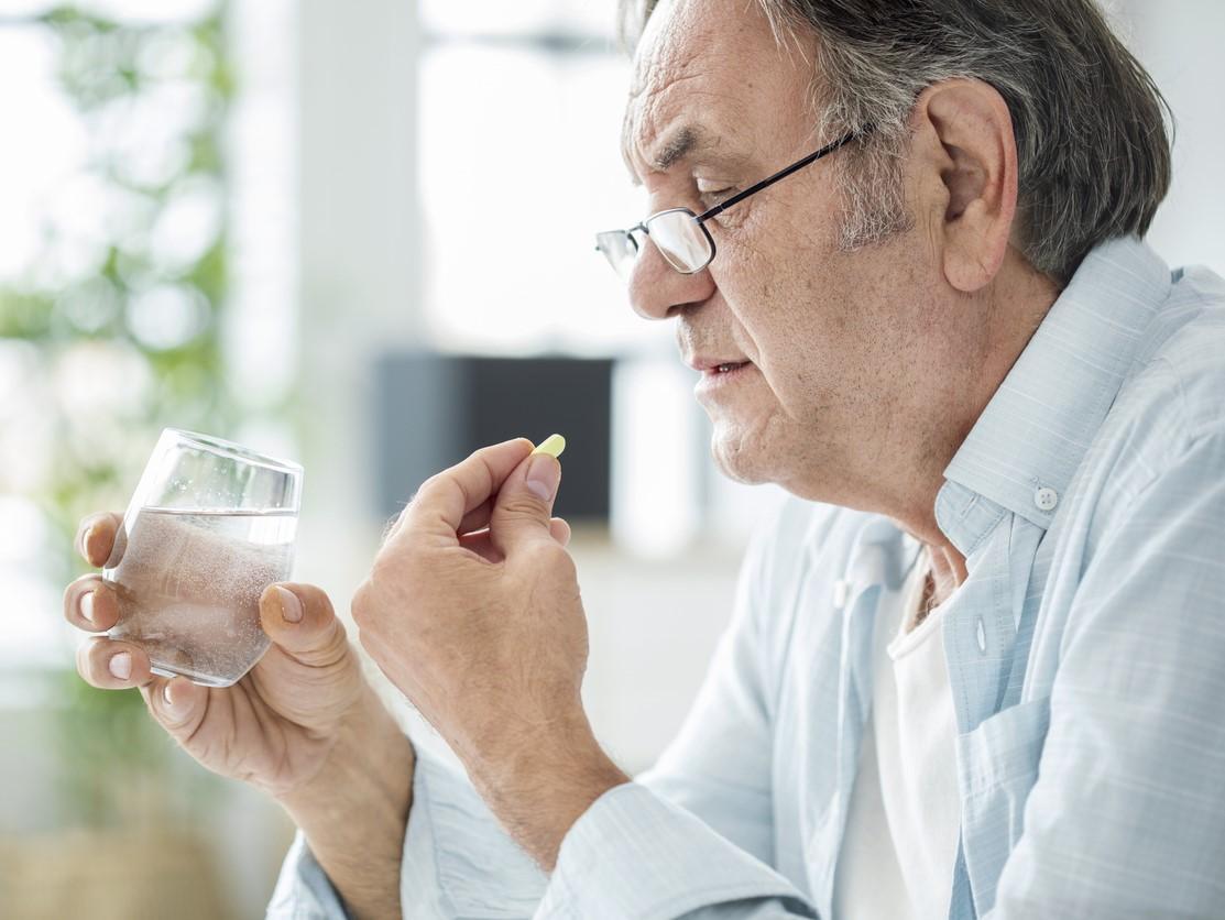 Older man taking pill