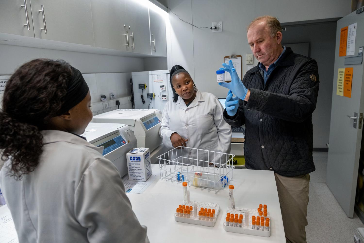Scientists in lab looking at TB sputum samples