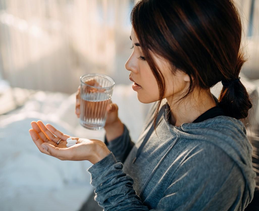 Woman taking white tablets