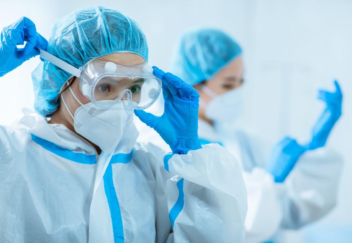 Asian doctors putting on personal protective equipment