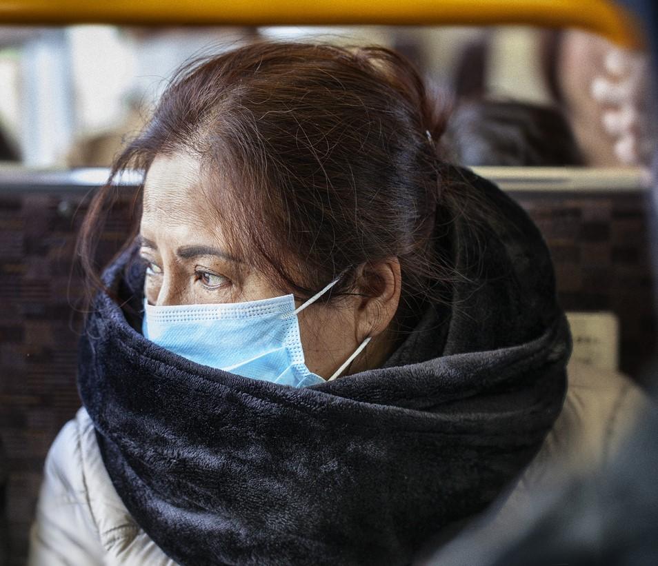 Asian woman wearing mask on bus