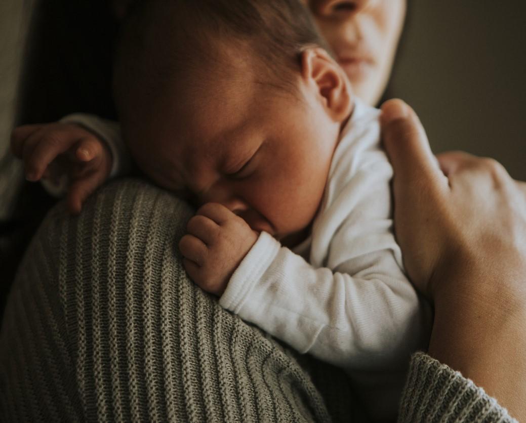 Baby snuggling on mom's shoulder