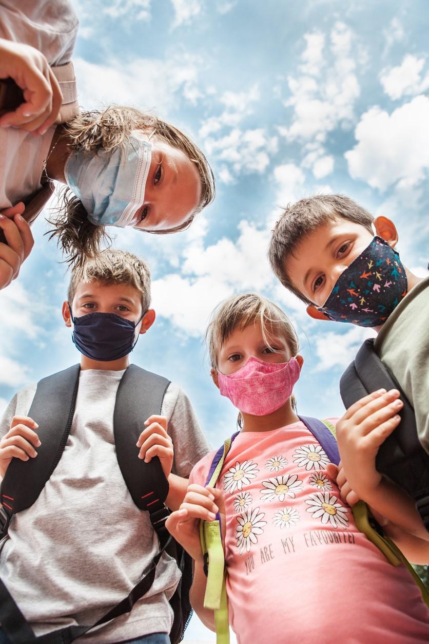 Circle of children wearing masks
