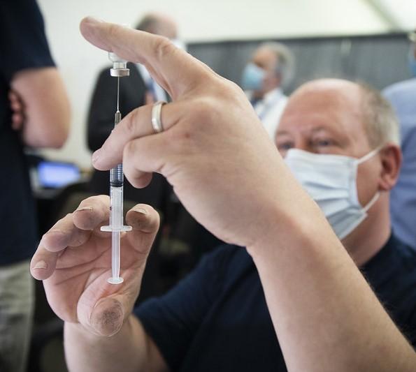 Clinic worker with vaccine vial and syringe