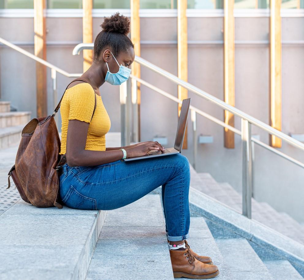 College student with laptop on steps