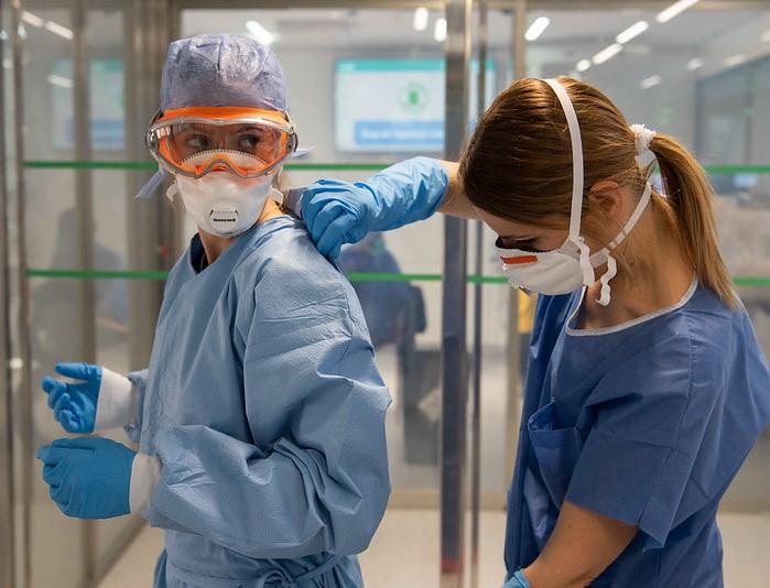 Healthcare workers donning COVID-19 protective equipment