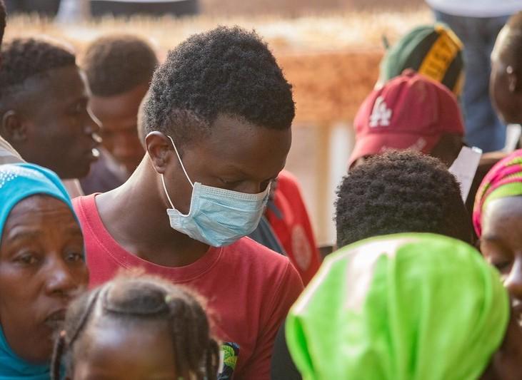 Crowd in Mali, one man wearing mask