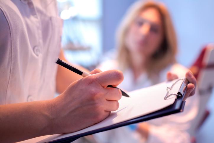 Doctor writing in patient's chart