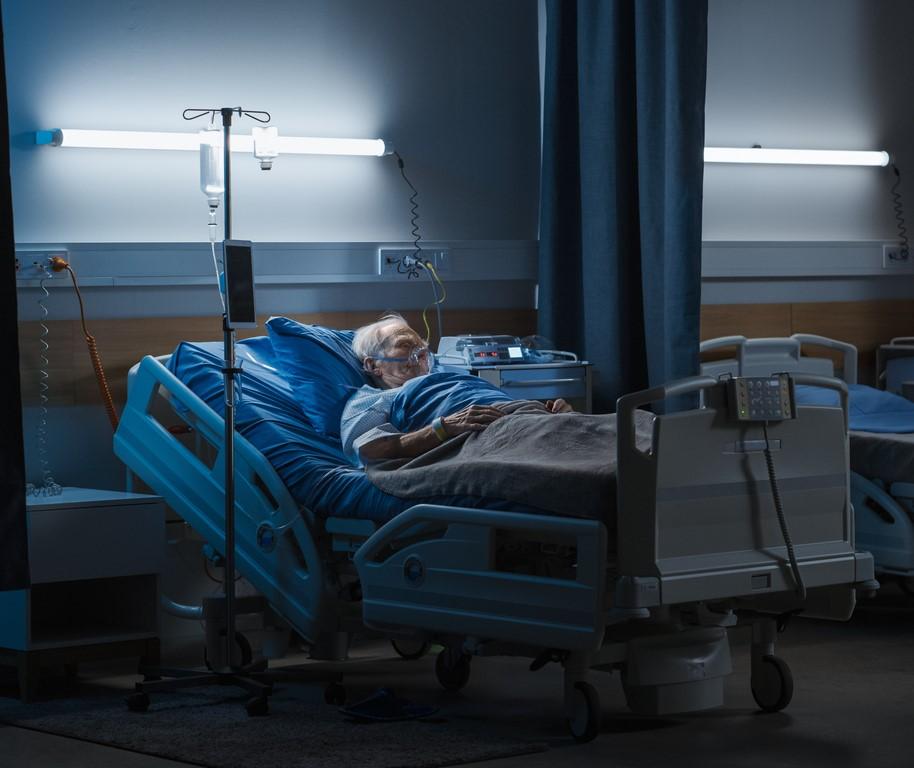 Elderly man in dark hospital room