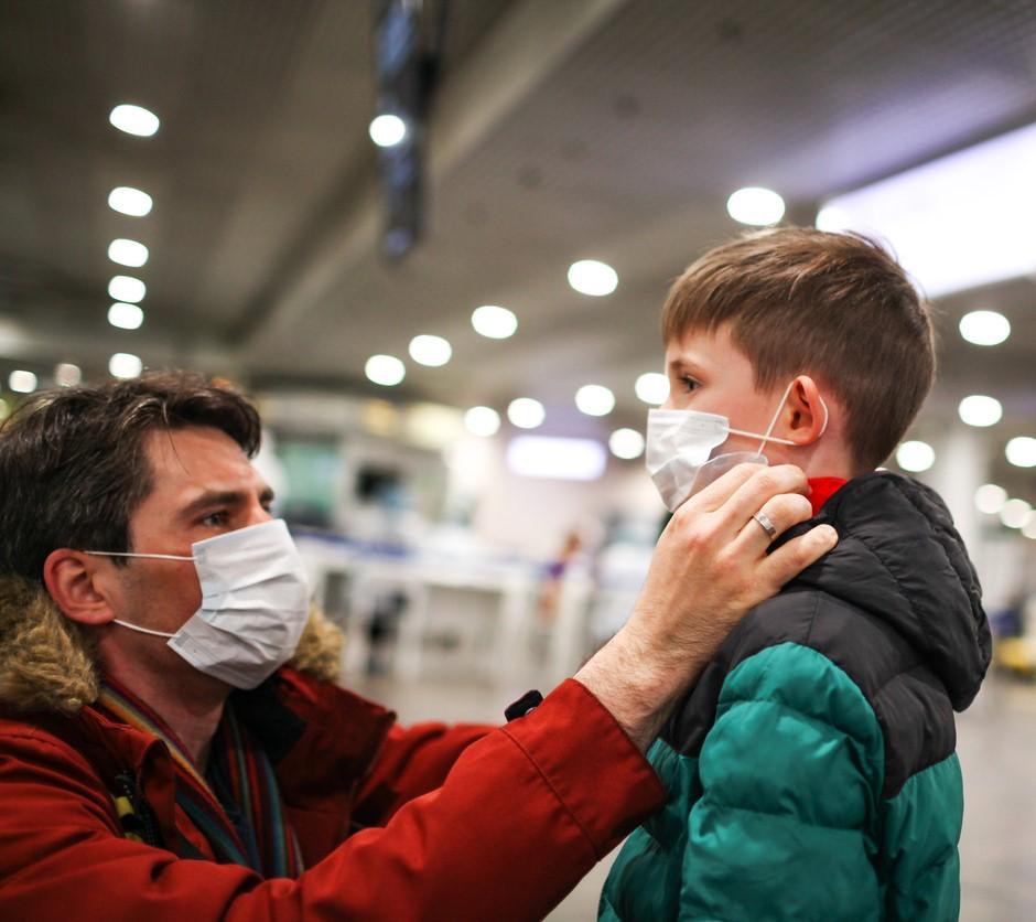 Father and son putting masks on in airport