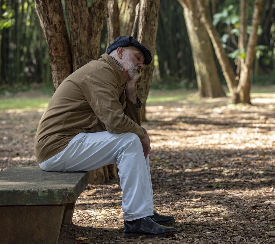 Tired older man on park bench