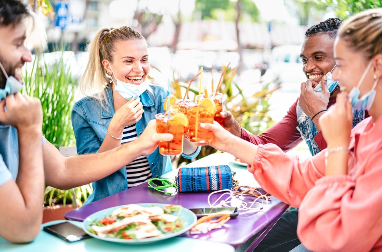 Friends drinking with masks down
