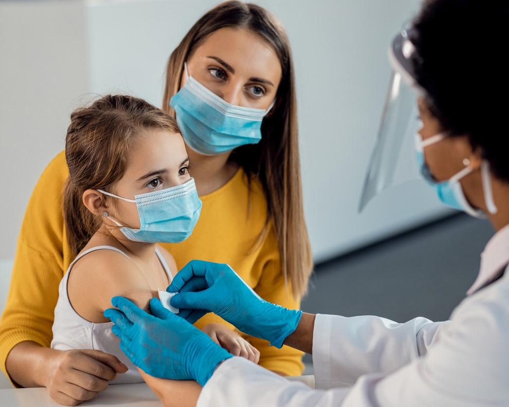 Girl getting bandaid after shot in arm