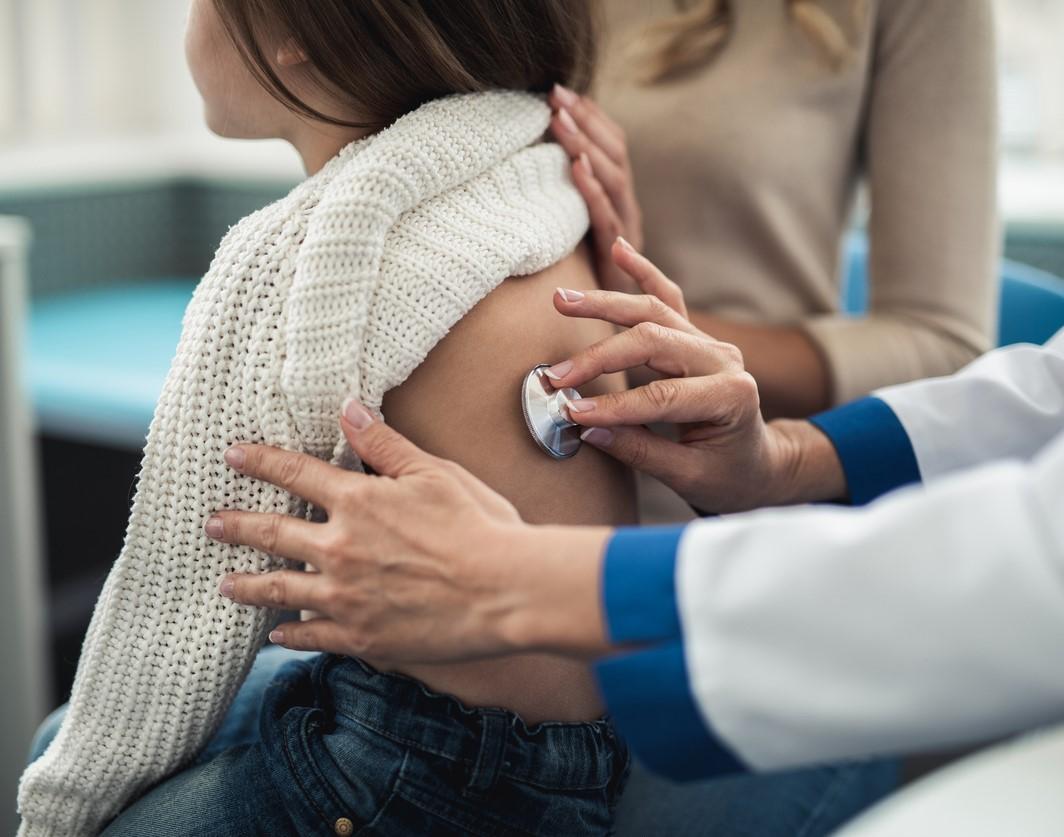 Doc with stethoscope on girl's back