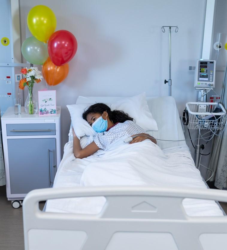 Girl wearing mask in hospital bed