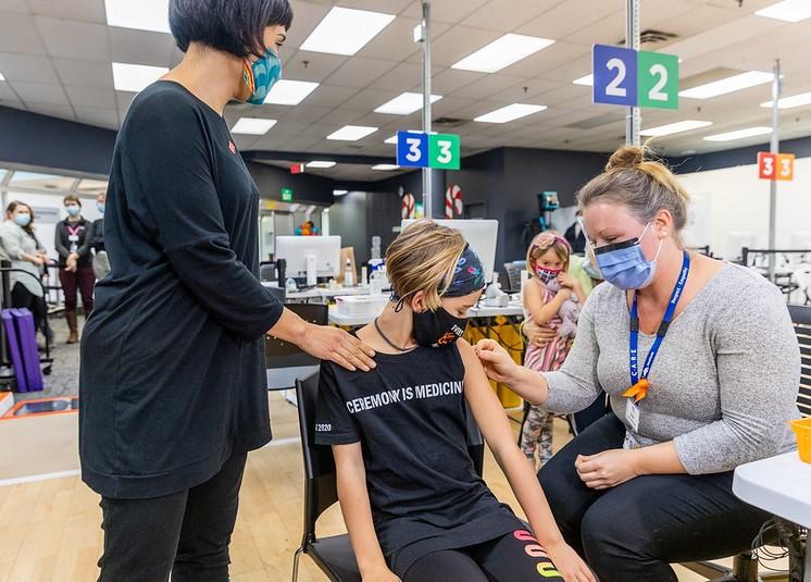 Girls getting vaccinated with mom
