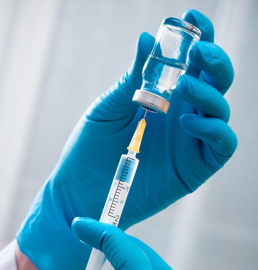 Gloved hands filling syringe