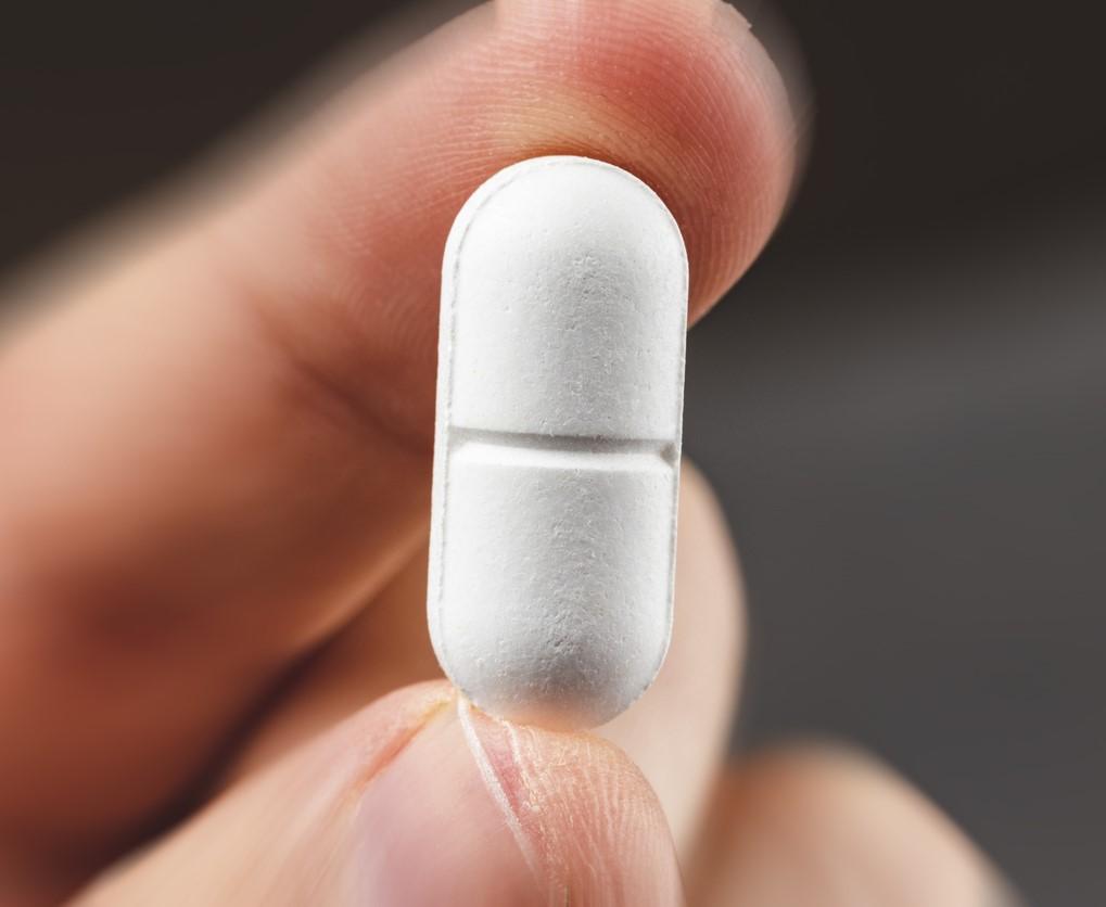Hand holding a white tablet