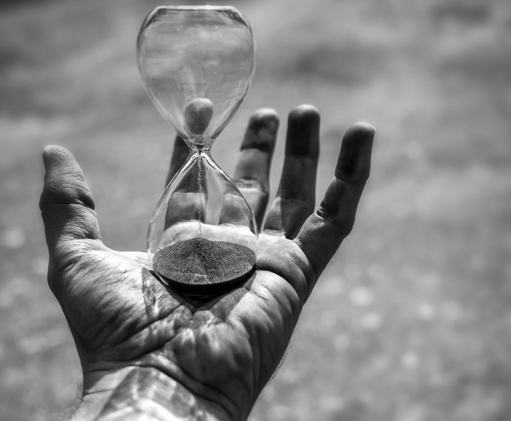 Hand holding an hourglass