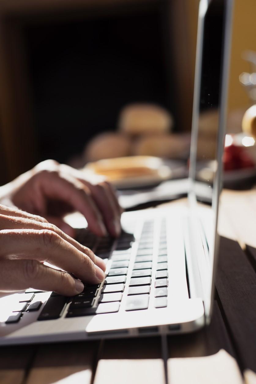 Hands typing on laptop computer