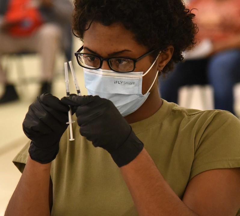 Healthcare worker holding 2 vaccine syringes