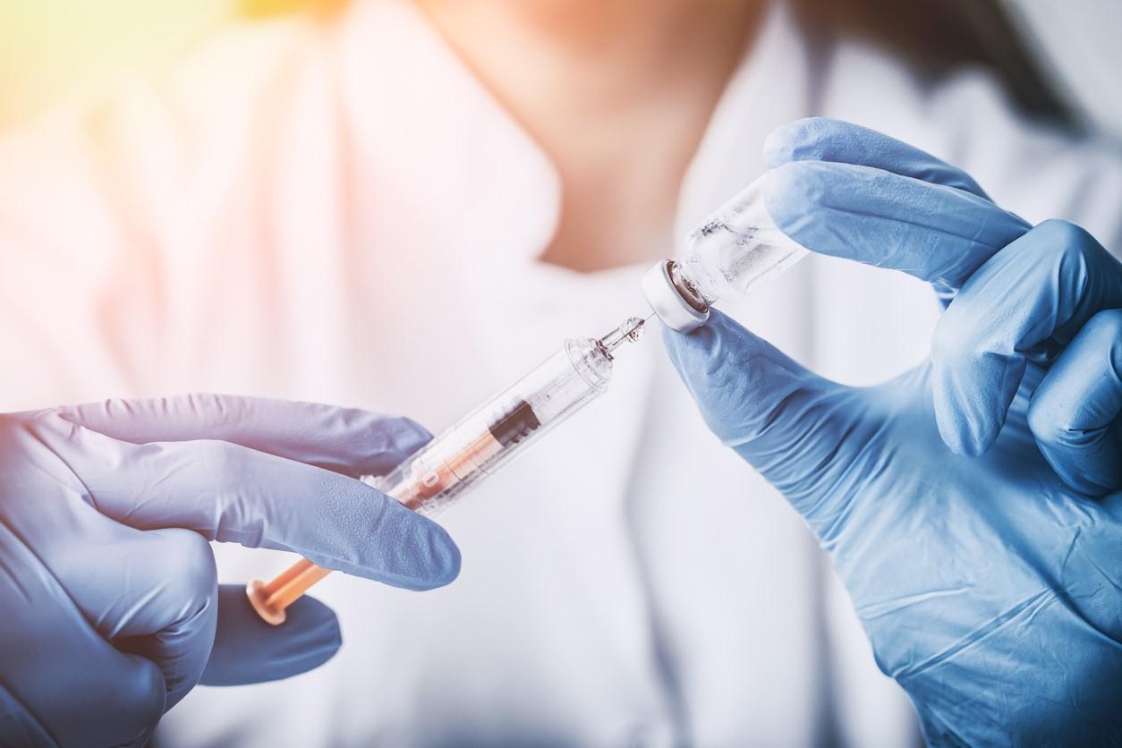 Health worker with syringe and vial