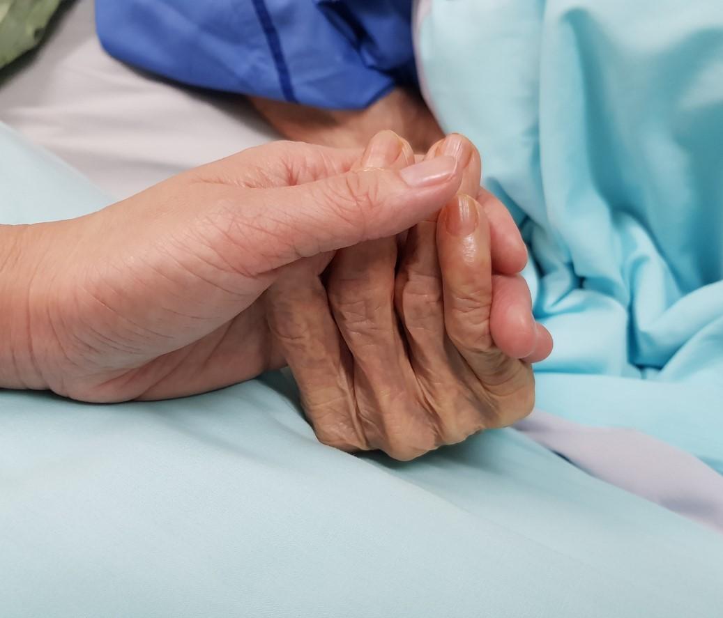 Holding older patient's hand