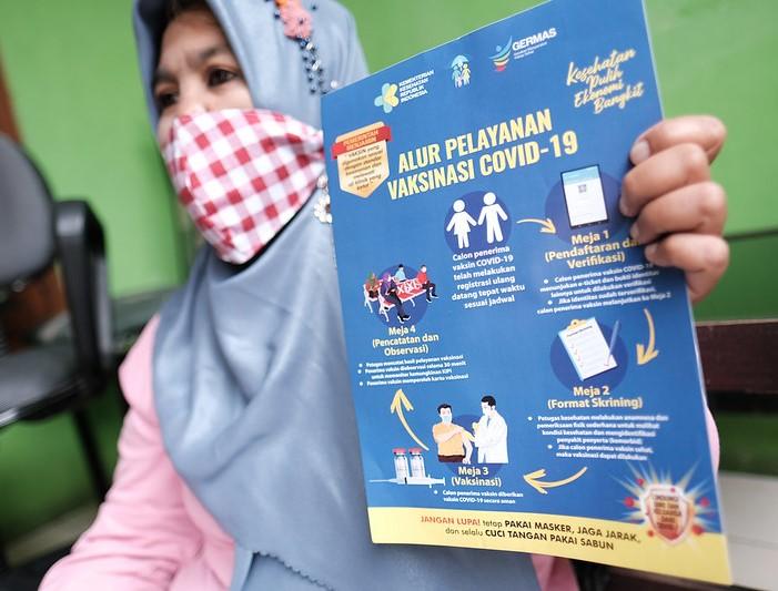 Indonesian woman with COVID pamphlet