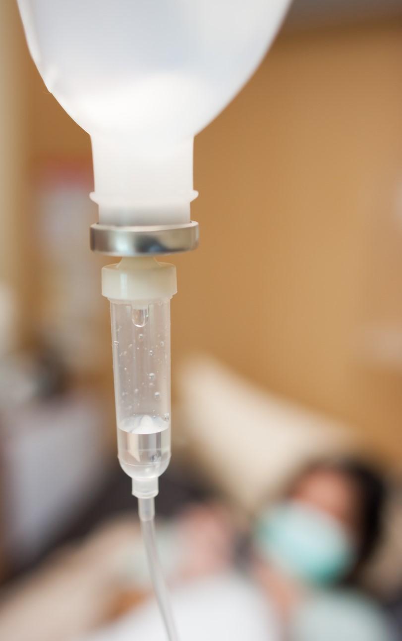 IV drip with blurred patient in background