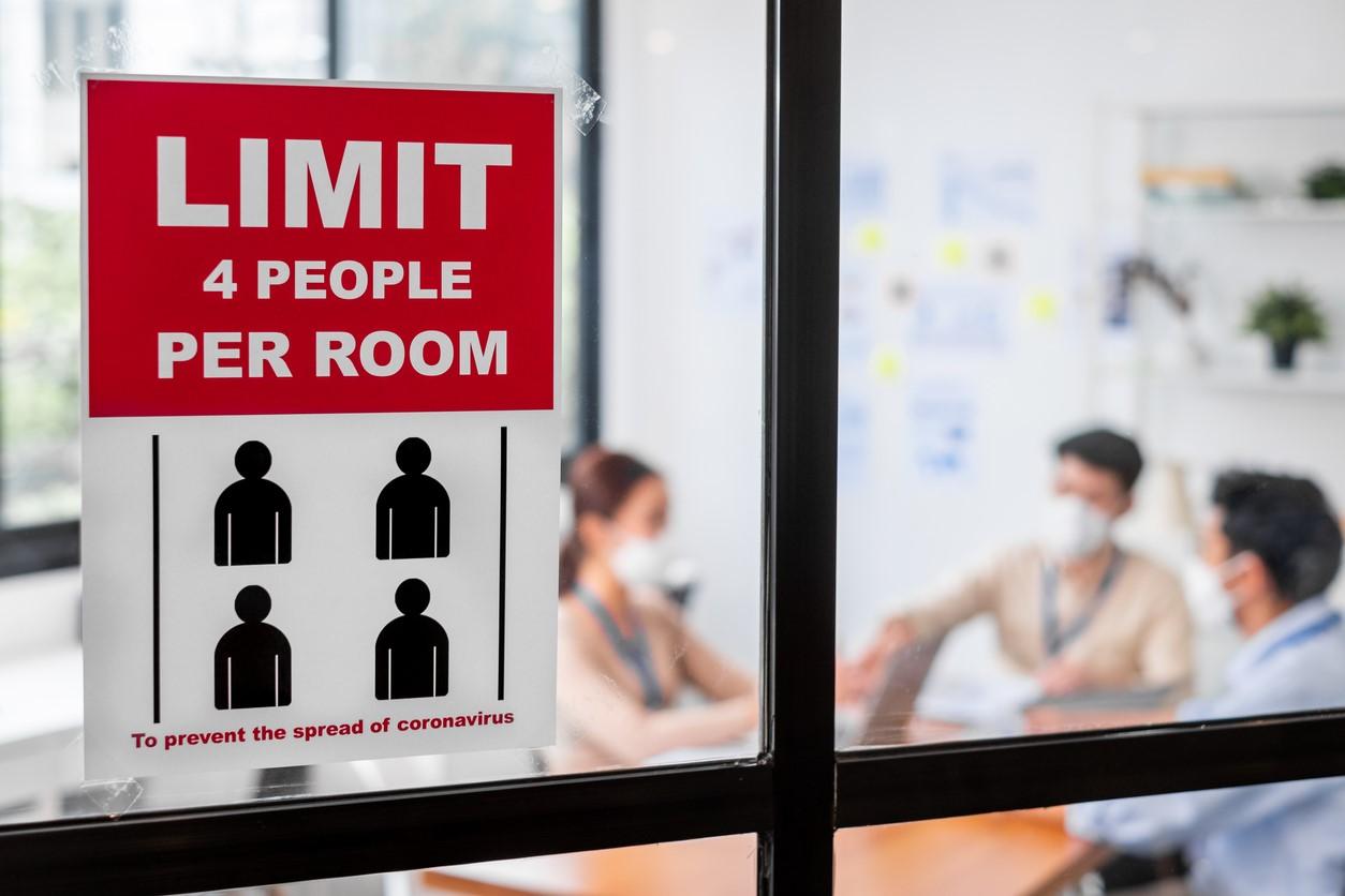 'Limit 4 people per room' sign