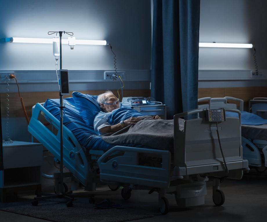 Man on oxygen in dark hospital room
