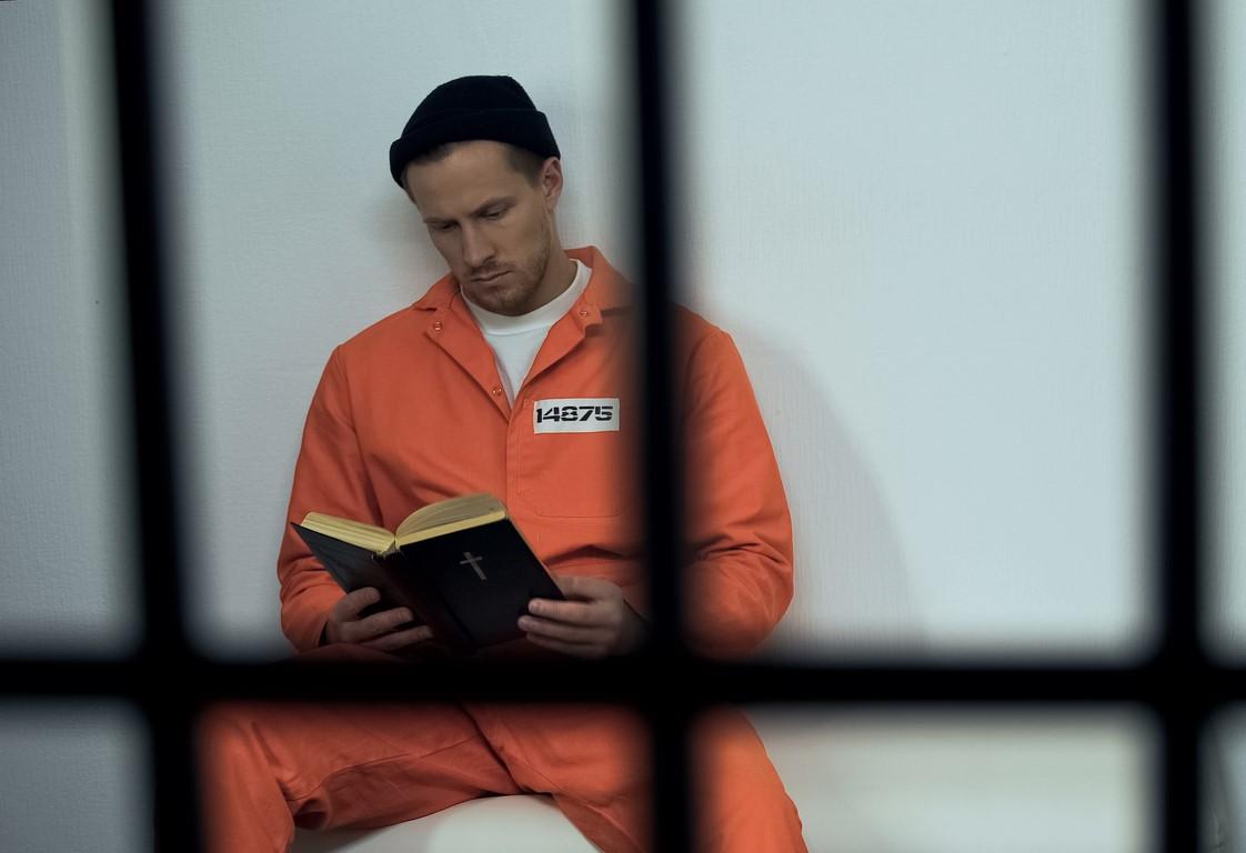 Man reading in prison cell