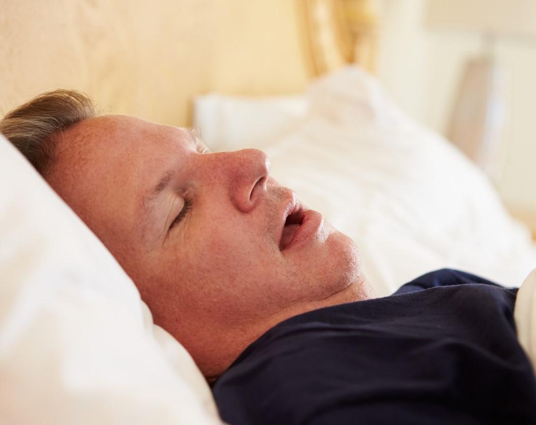 Man snoring in bed