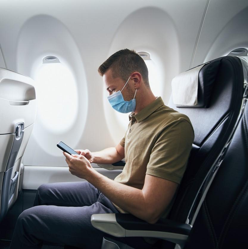Man wearing surgical mask on plane