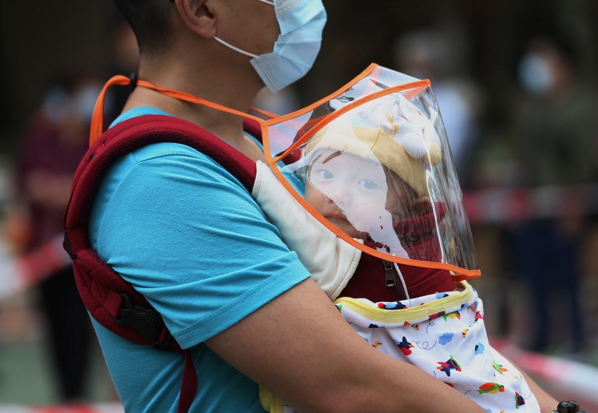 Man with baby in line for COVID testing