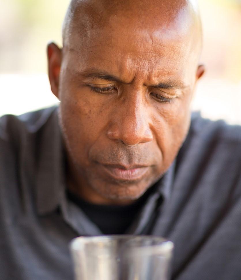 Man with drink looking troubled