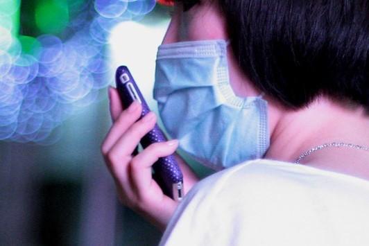 Woman with cell phone and surgical mask