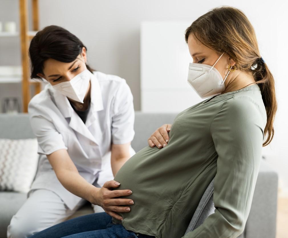 Masked doula with masked pregnant woman