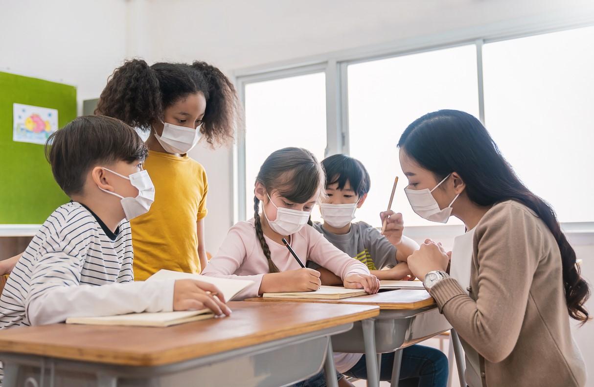 Masked teacher with students