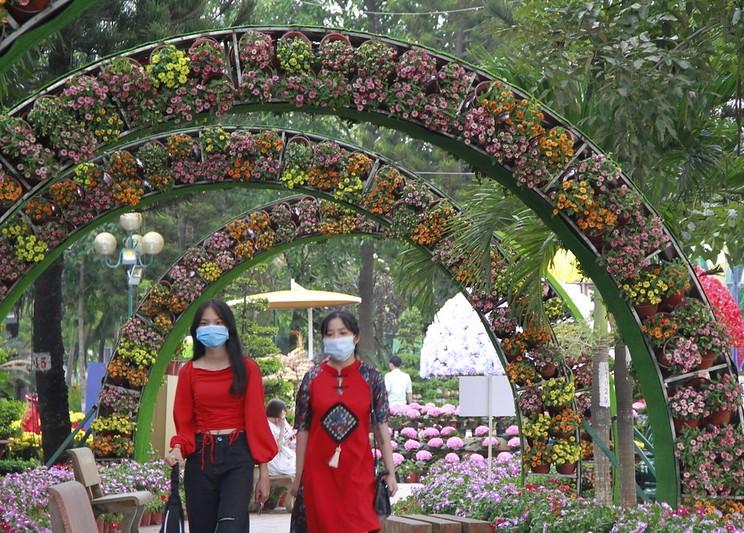 Masked women under flowered archways