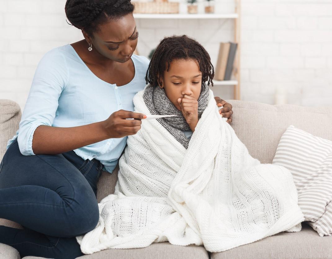 Mother taking daughter's temperature