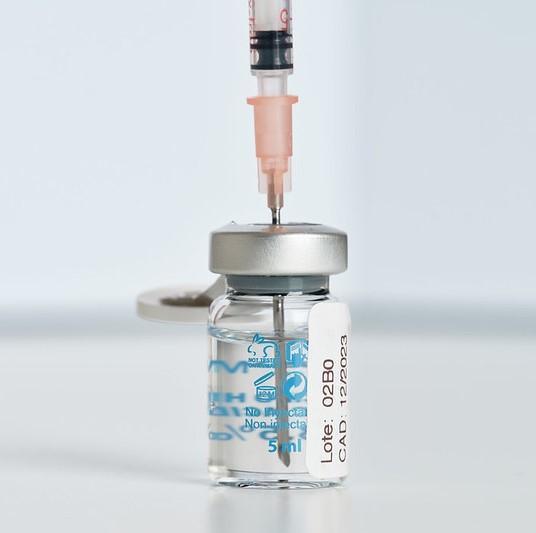 Needle inserted into Pfizer COVID vaccine vial