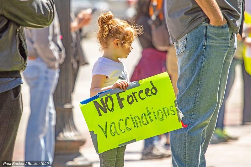 Girl with 'no forced vaccinations' sign