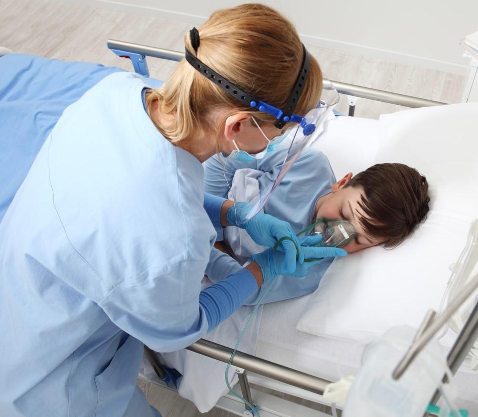 Nurse giving oxygen to sick boy